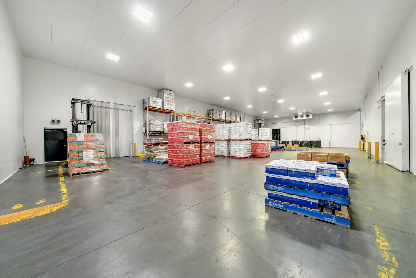 Commercial real estate photographer Melbourne — bright cold-store warehouse interior with pallet racking and polished concrete floor